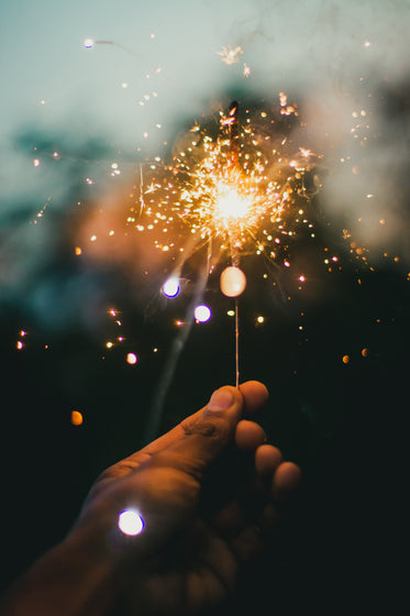 hand holds up brightly lit sparkler