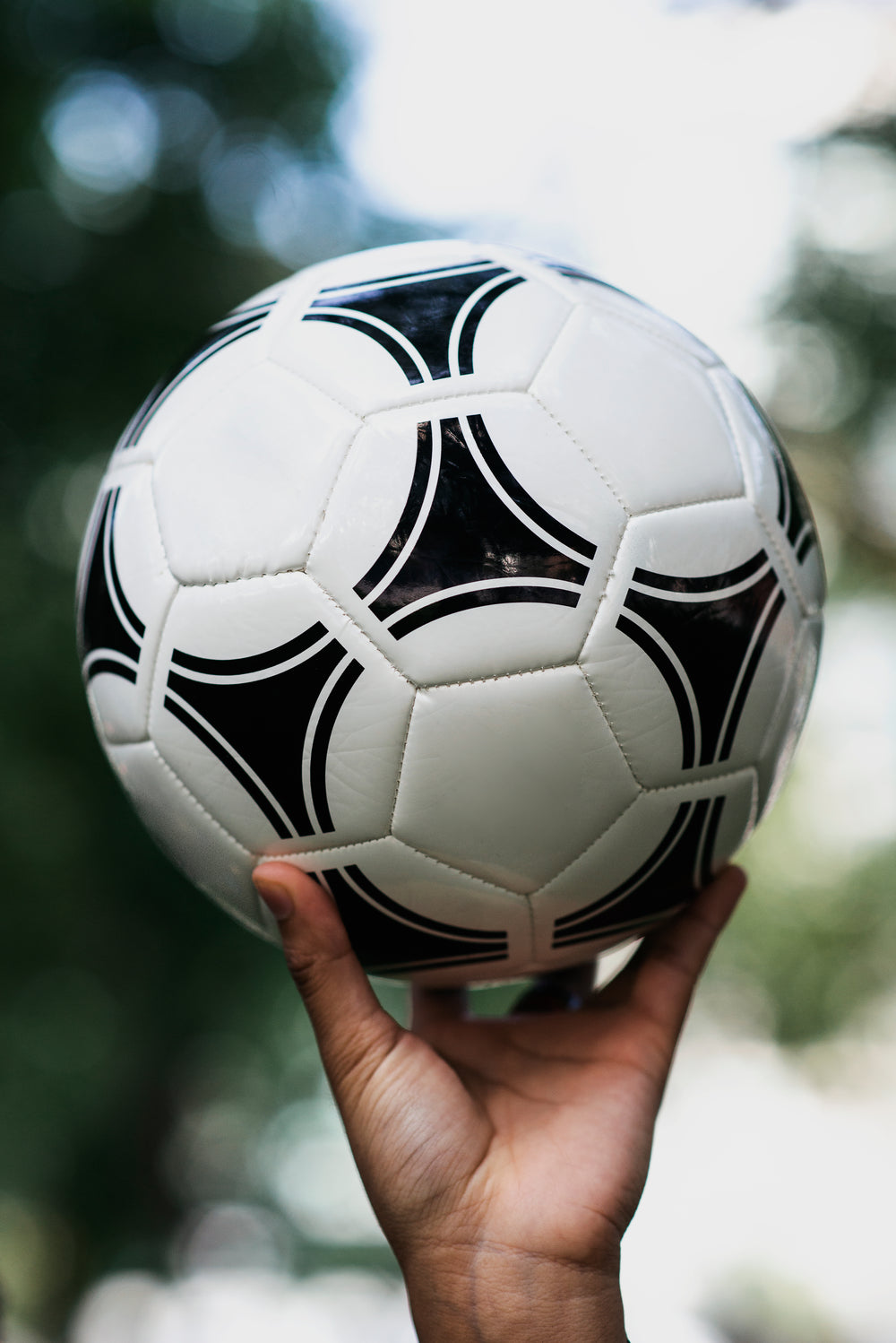 hand holds up soccer ball