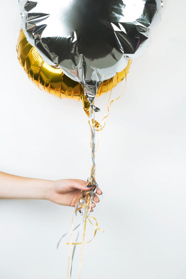 hand with metallic balloons