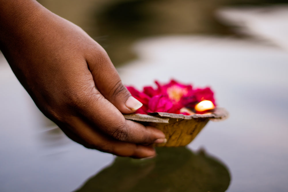 hand picks up a bowl full of pink petals