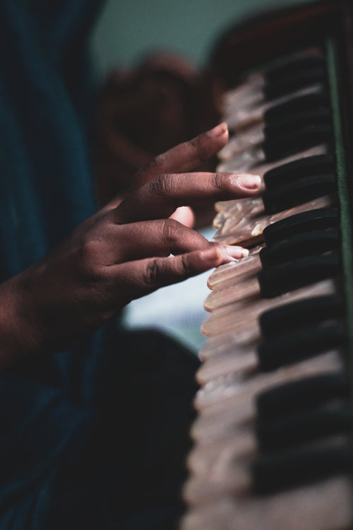 hand playing on white iridescent piano keys