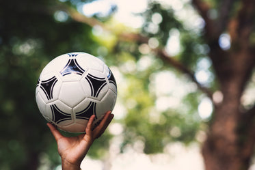 hand reaching up with soccer ball