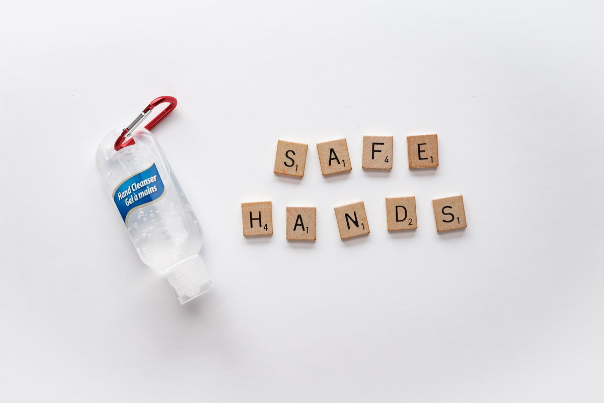 hand sanitizer and letter tiles spelling safe hands