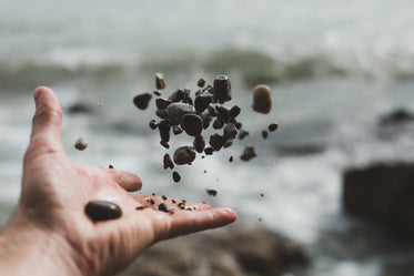 hand tossing pebbles