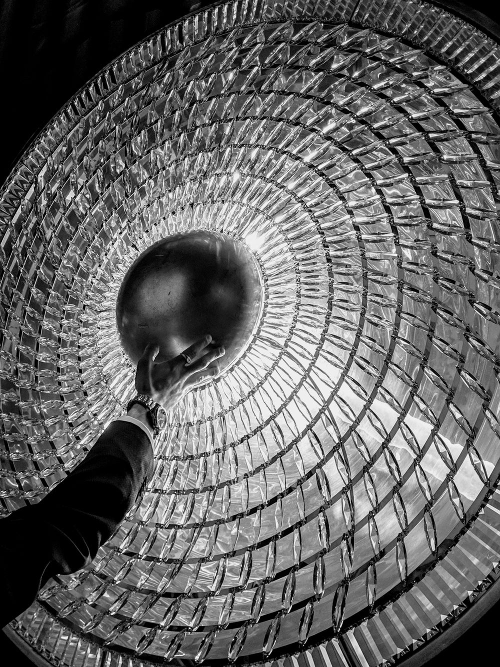 hand touches the center of a crystal light