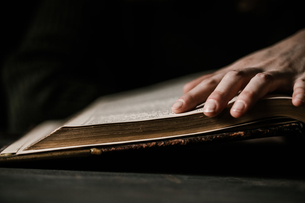 hand traces lines on large old bible