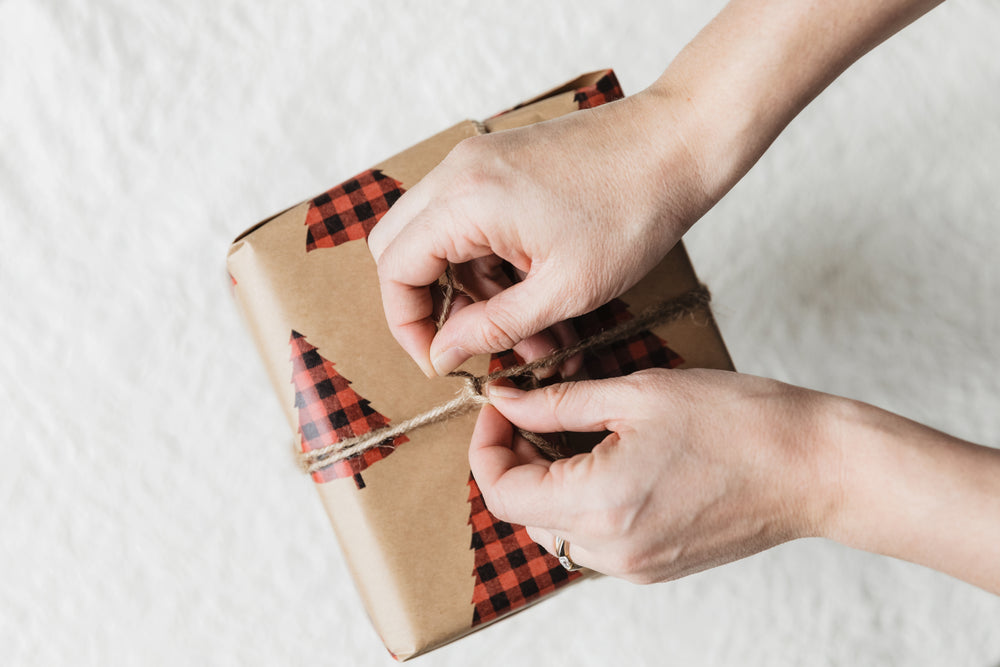 hand tying twine on holiday gift