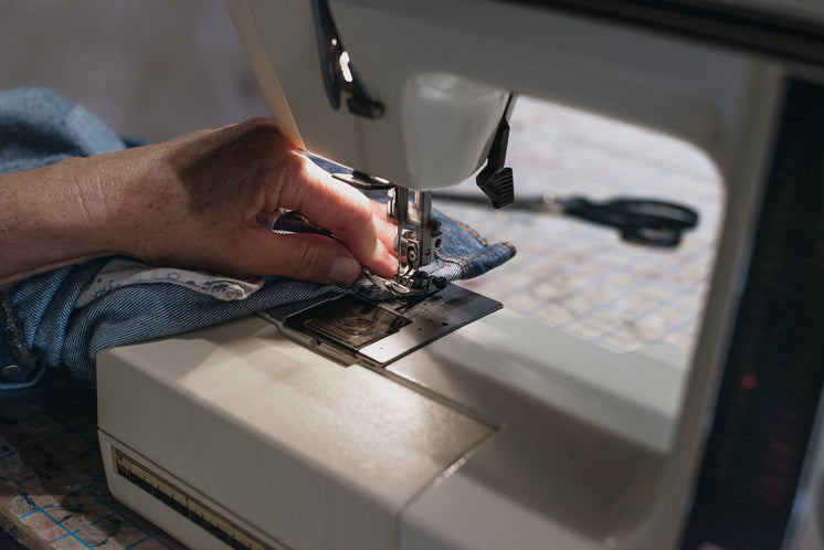 hand-uses-sewing-machine-on-denim.jpg?wi