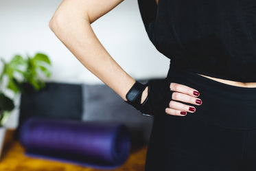 hand with red nails and fitness gloves on hip