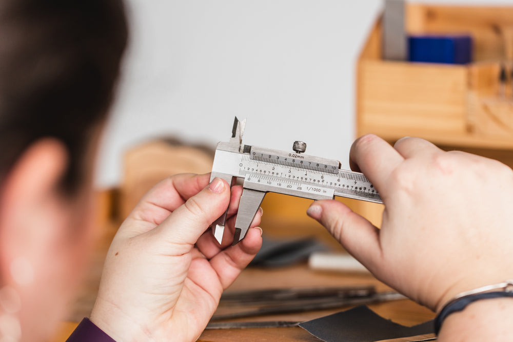 hands carefully adjust caliper