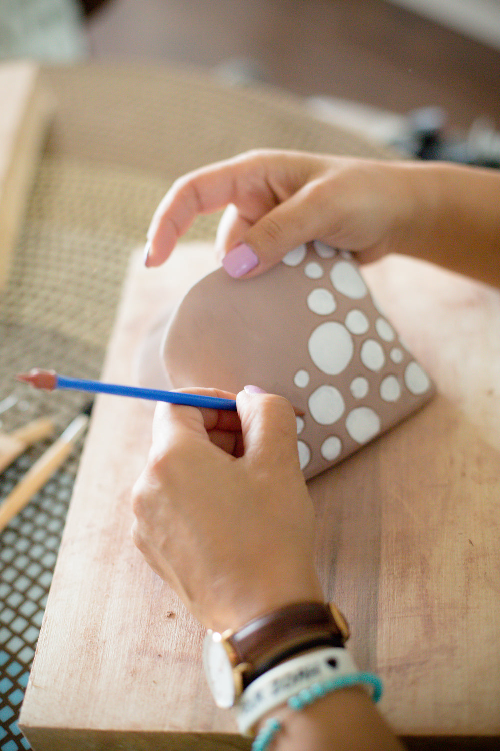 hands crafting over wooden board