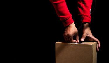 hands creating with string and box