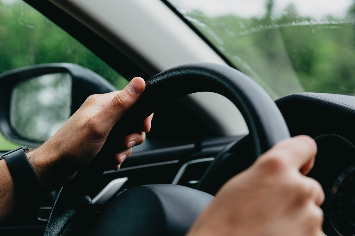 hands grasping a steering wheel