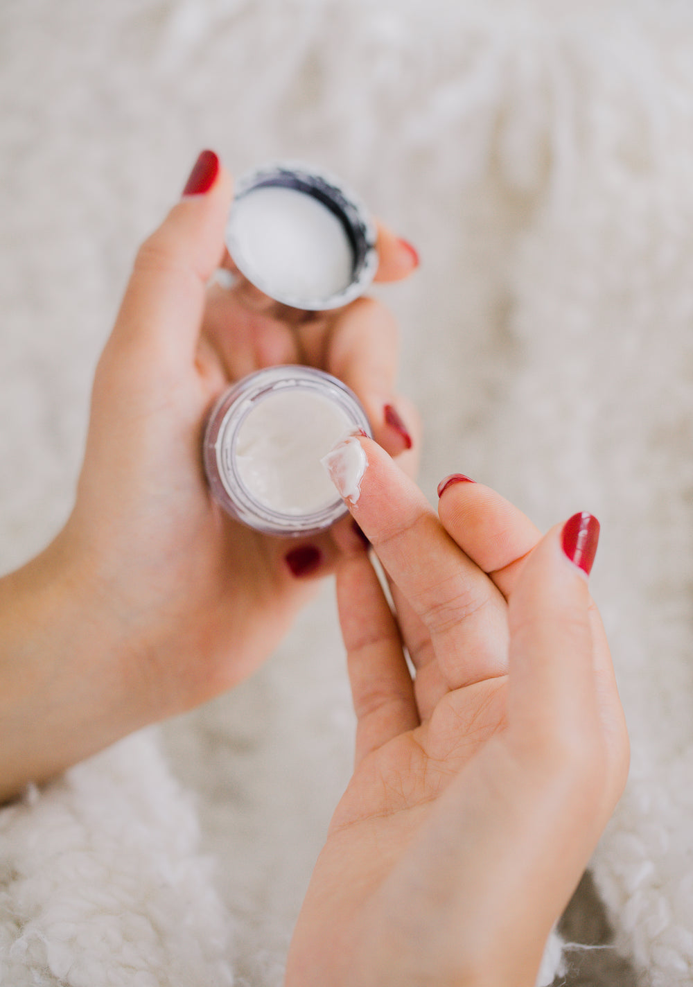 hands hold a small cosmetics container