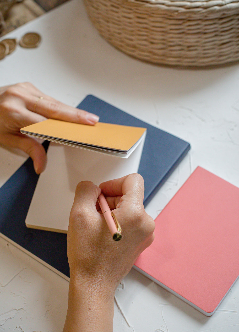 hands hold and write in a yellow notebook