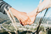 hands hold each other in front of distant view