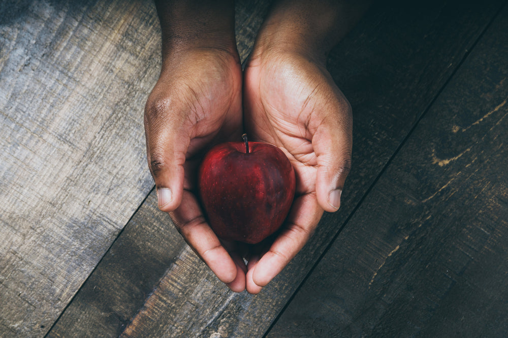 hands hold red apple