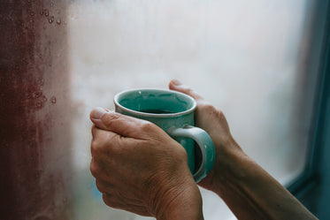 hands holding a green mug