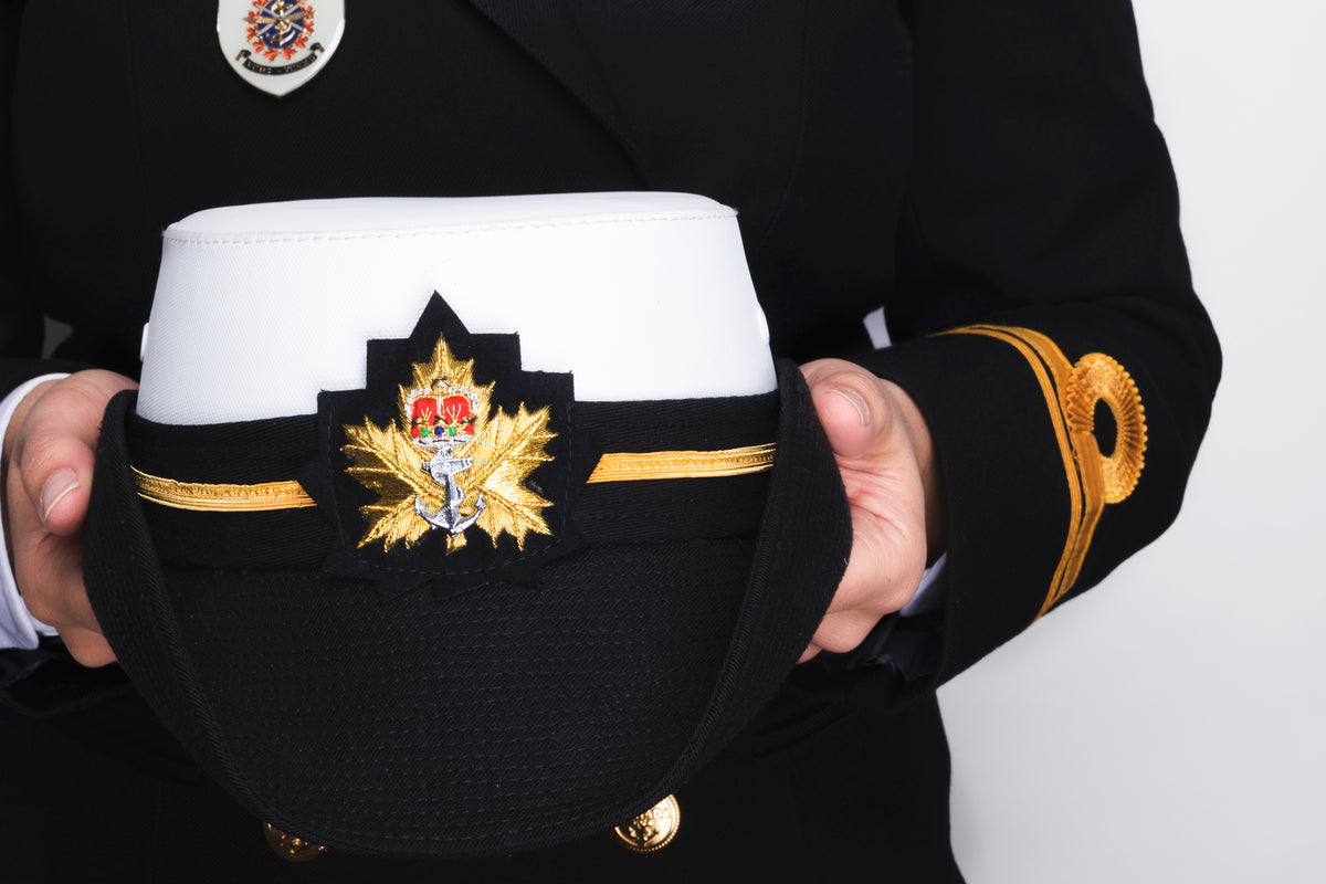 hands holding a navy peaked cap