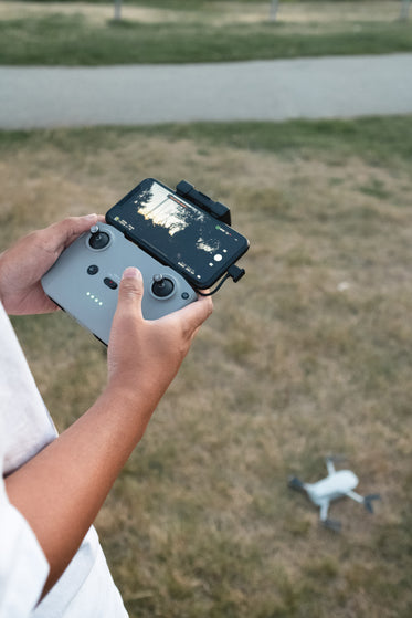 hands holding the controls of a drone