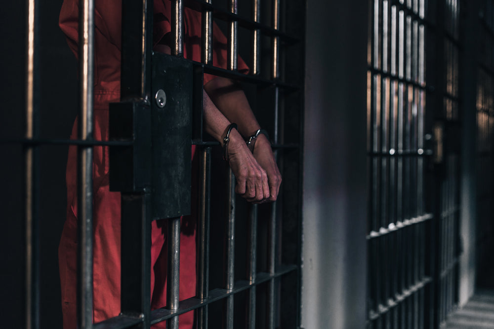 hands in handcuffs in a prison cell