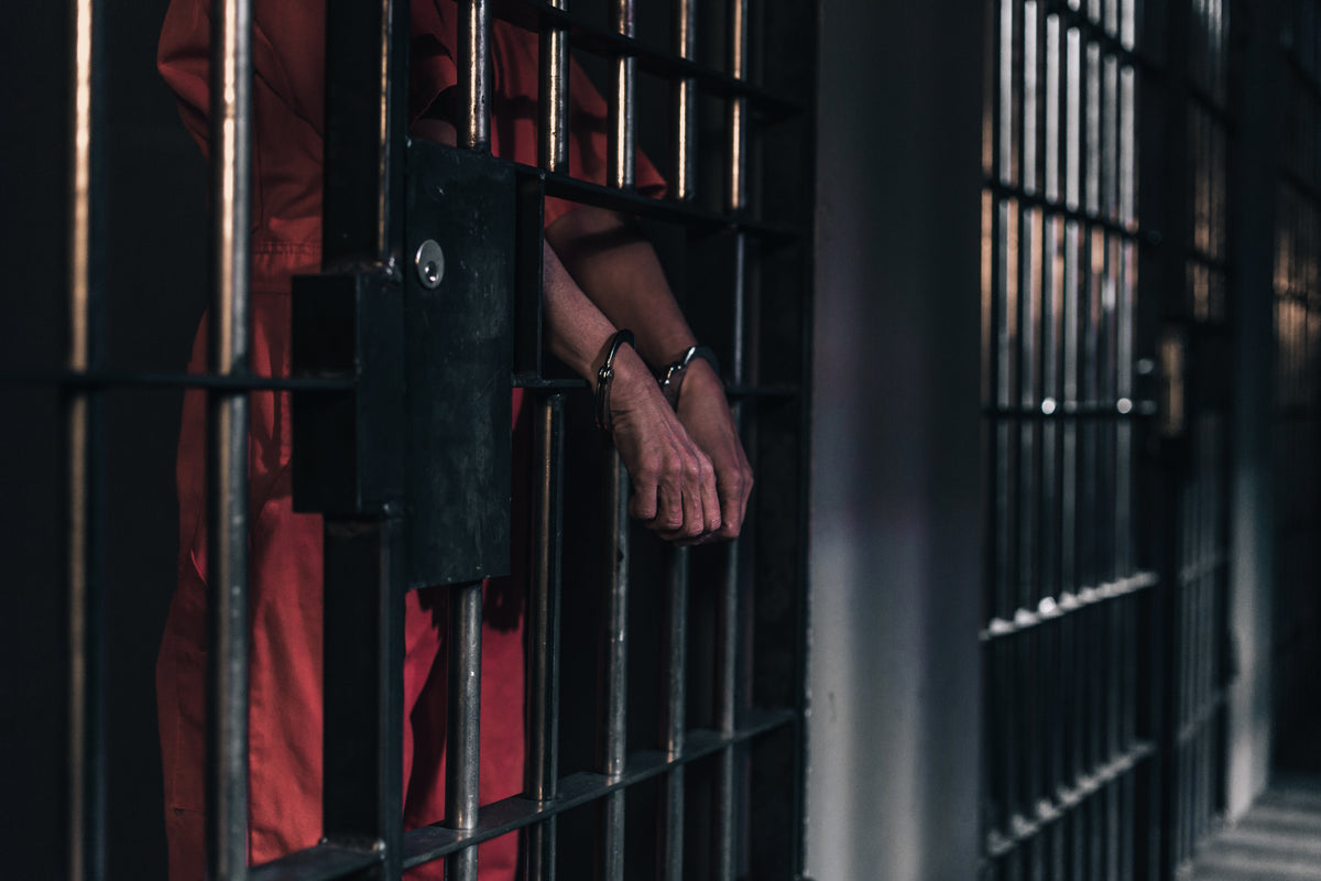 hands in handcuffs in a prison cell