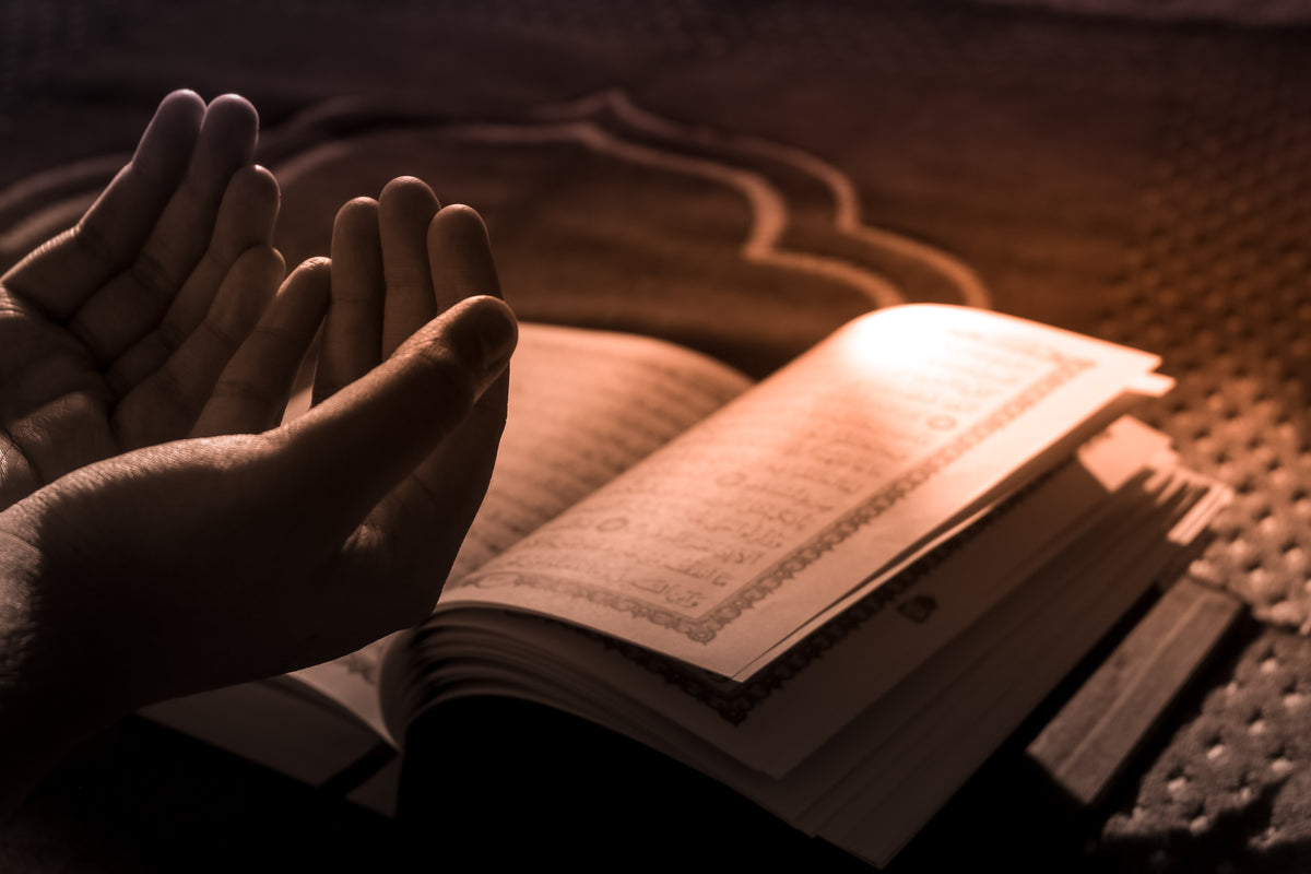 hands in prayer with prayer book