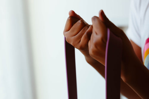 hands tightly grip a purple rope