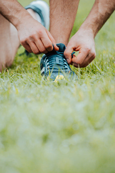 hands tying shoe laces on a running shoe