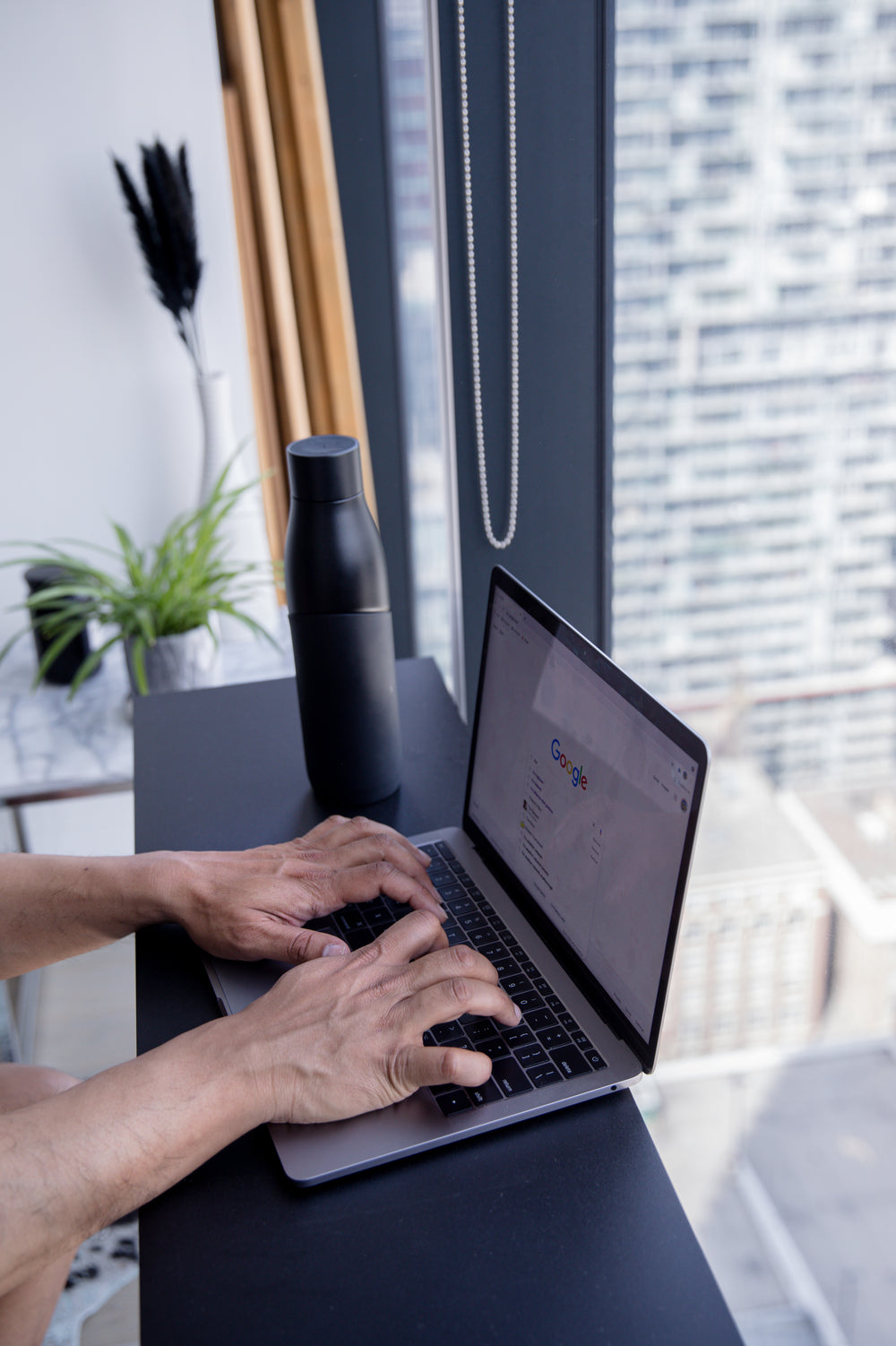 hands type on a laptop with google home screen