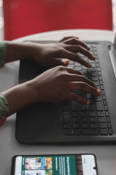 hands typing on a black keyboard