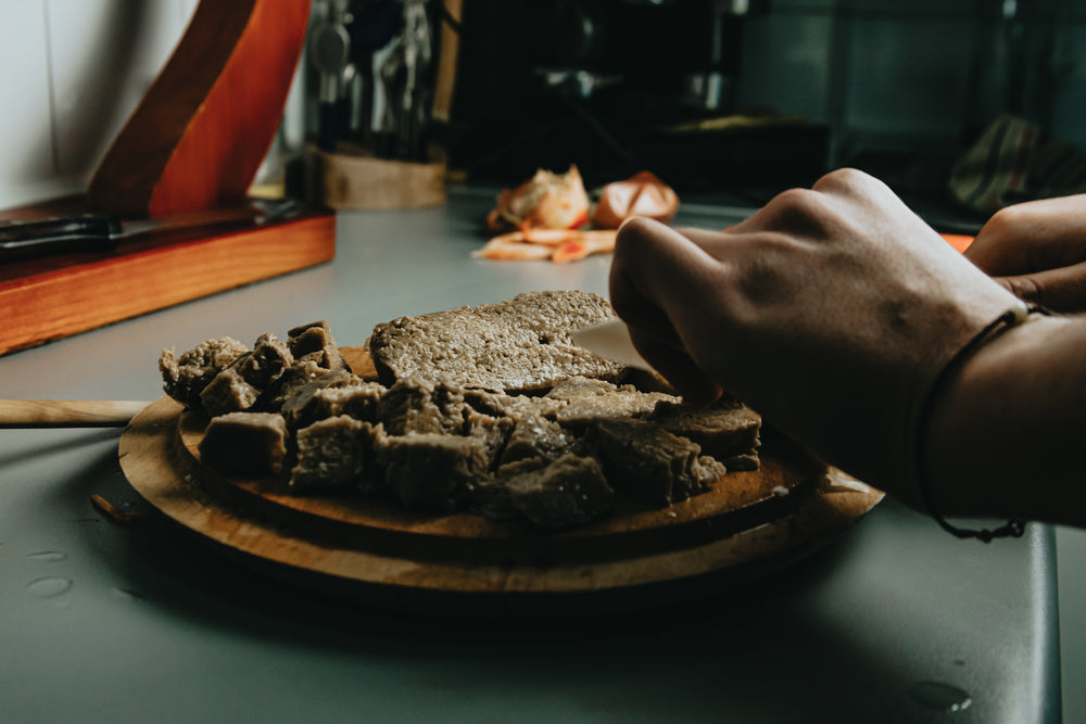 hands use a knife to cut up meat