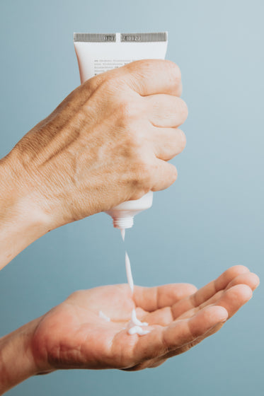 hands using a tube of hand cream