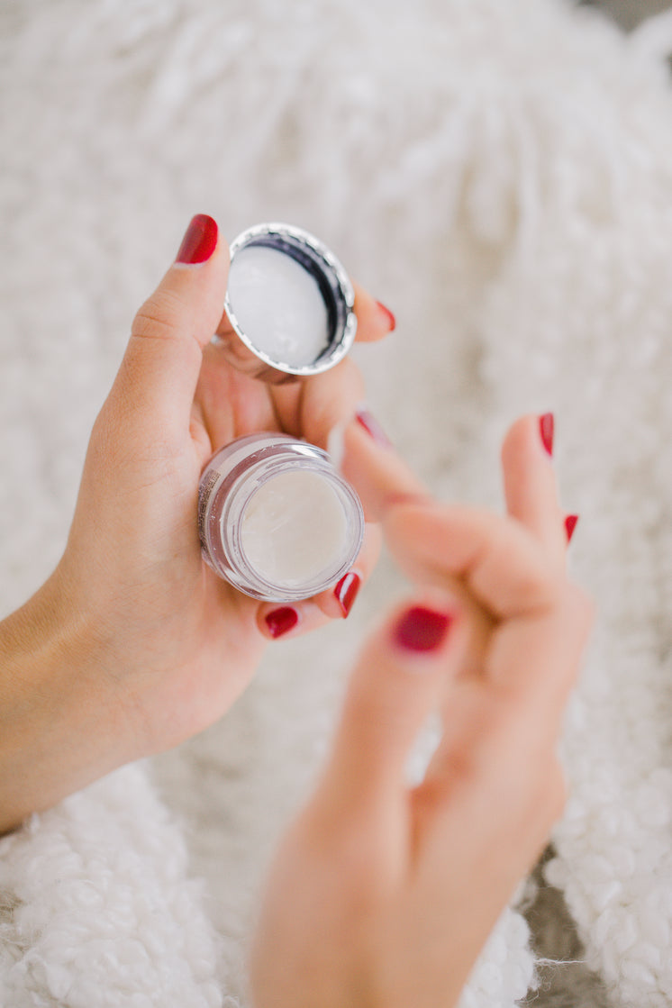 hands-with-red-nails-hold-a-small-cosmet