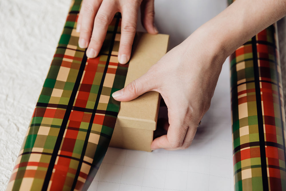 hands wrapping presents with paper