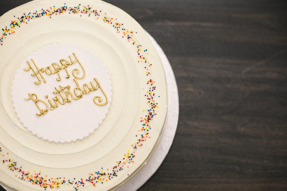 Yellow sugar buttercream birthday cake on a circle porcelain plate