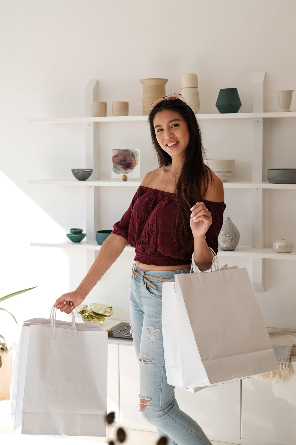 happy customer smiles and holds white shopping bags