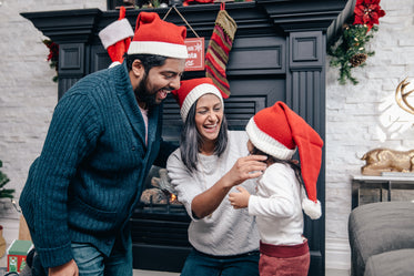 família animada com chapéus de papai noel