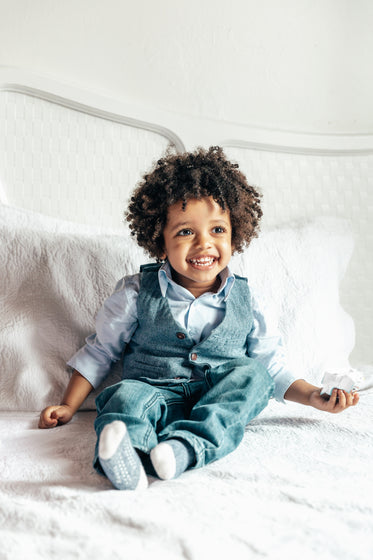 happy little boy sitting on bed