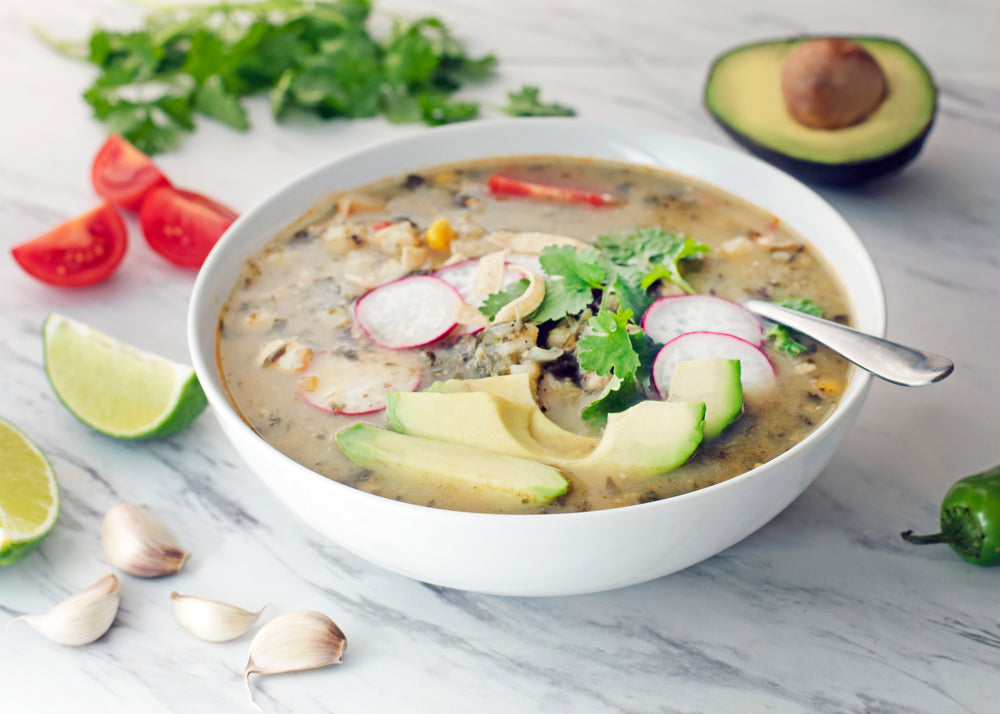 hearty bowl of vegetable noodle soup on marble counter