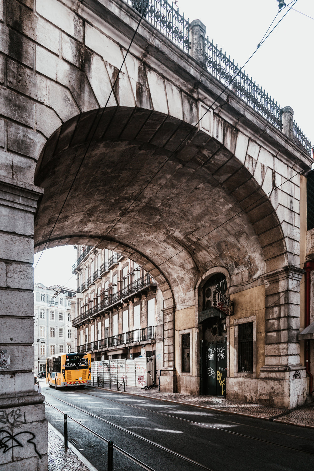 high arching bridge over lisbon city street