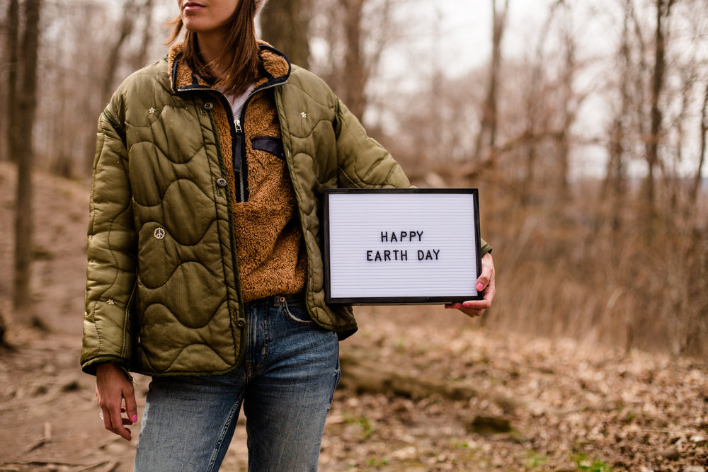 hiker holds up a sign for earth day