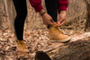 hiker in the woods stops to tie laces
