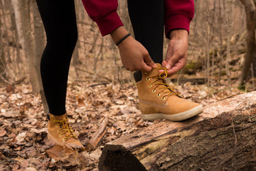 hiker in the woods stops to tie laces
