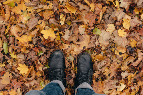 hiker looks down at boots and leaves