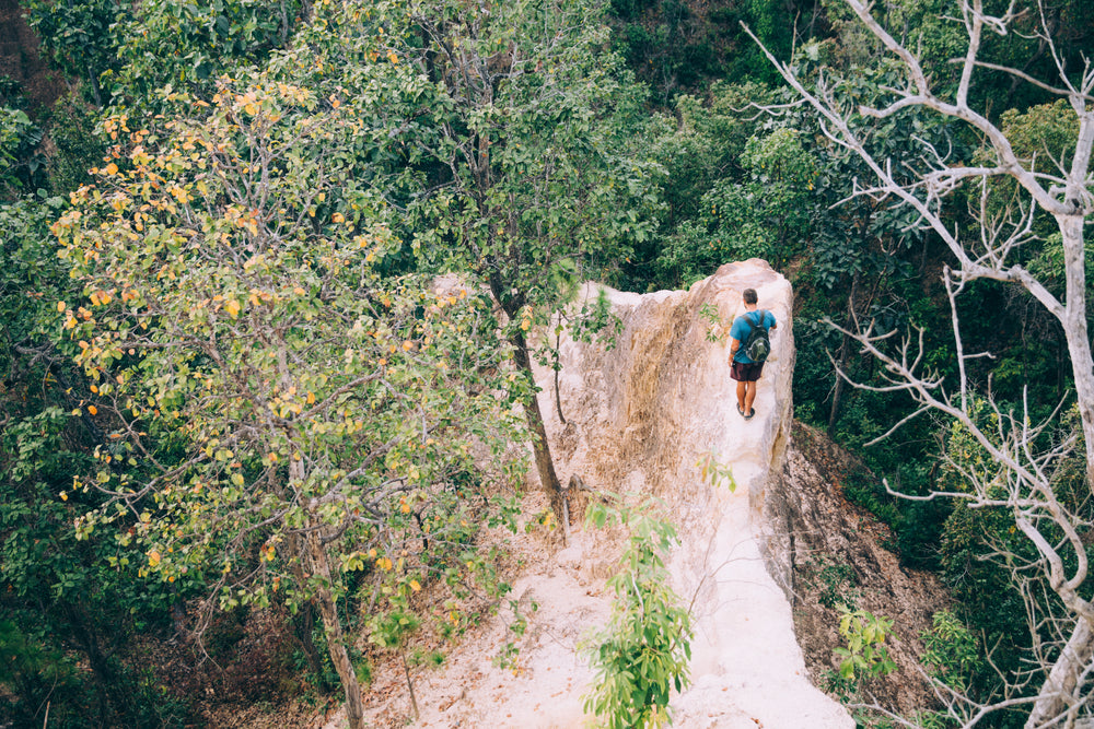 hiker navigates a narrow rock face