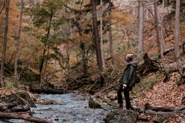 hiker near stream in autumn