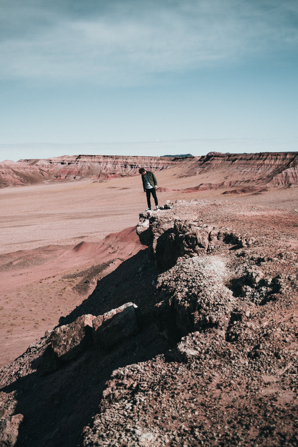 hiker peaks over rocky edge