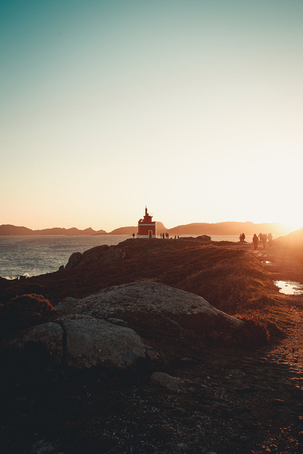 hikers flock to lighthouse at sunset