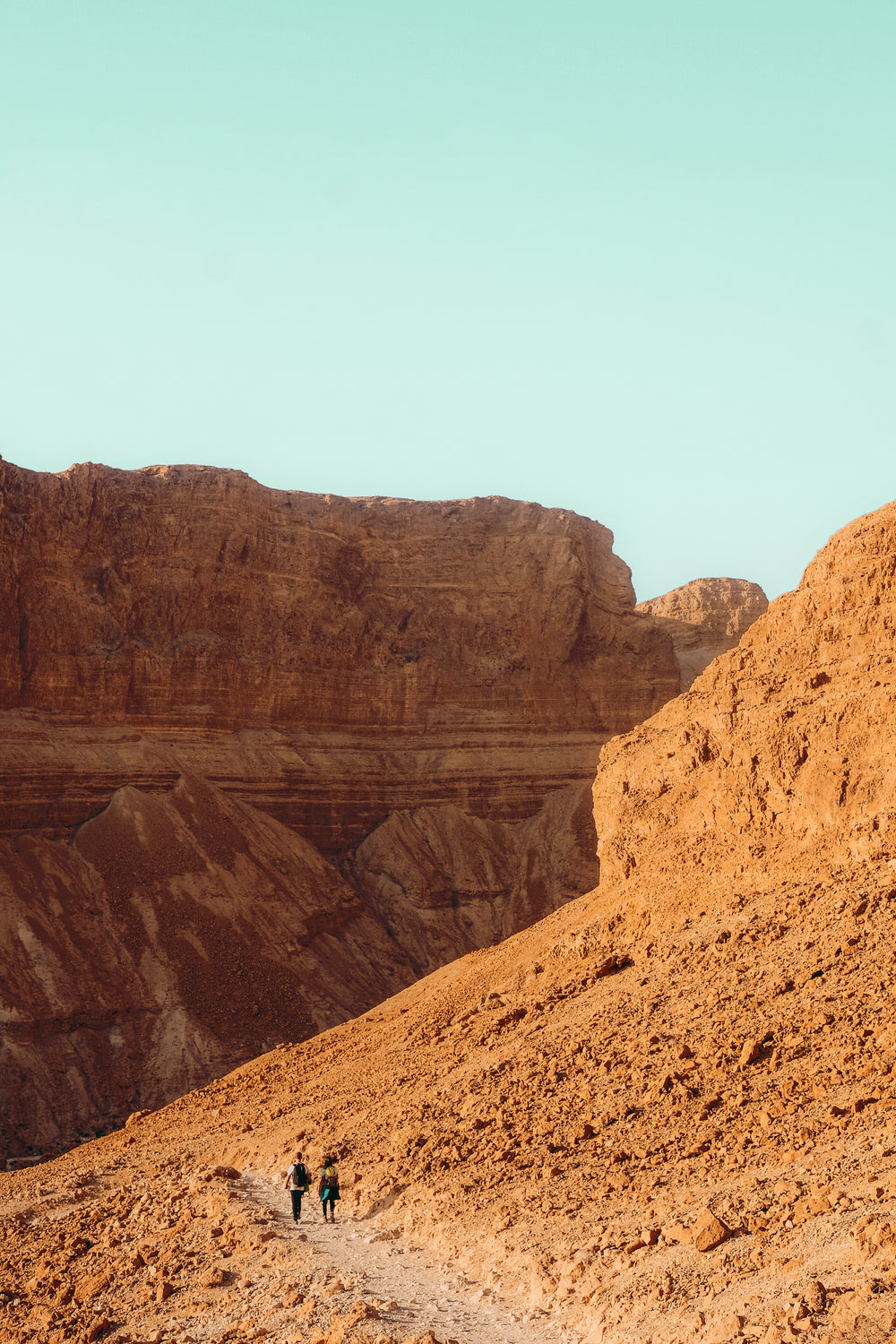 hikers on a red sandy desert hill